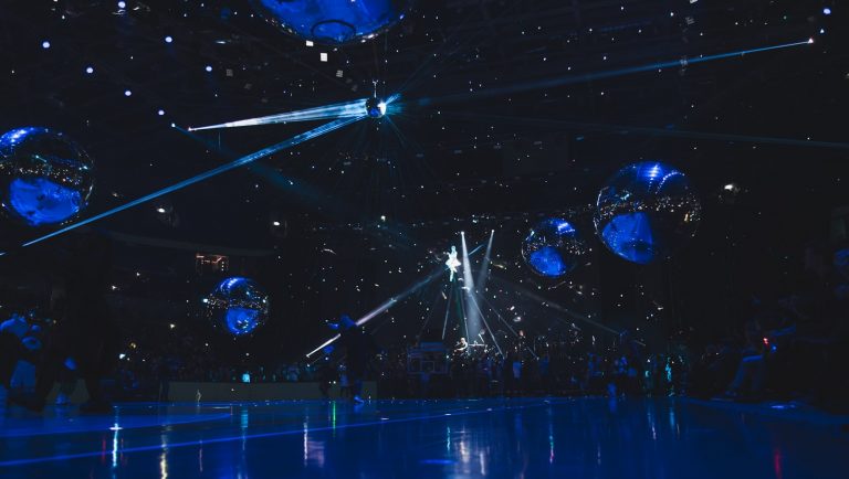 a group of people standing on top of a blue floor